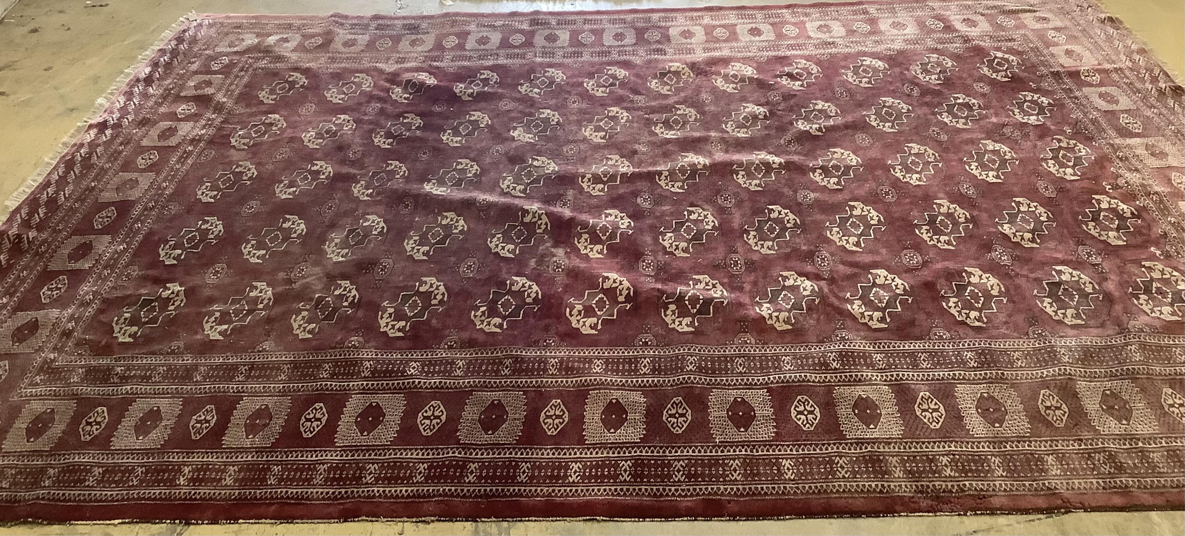 An antique Bokhara carpet, 384 x 286cm. Condition - fair